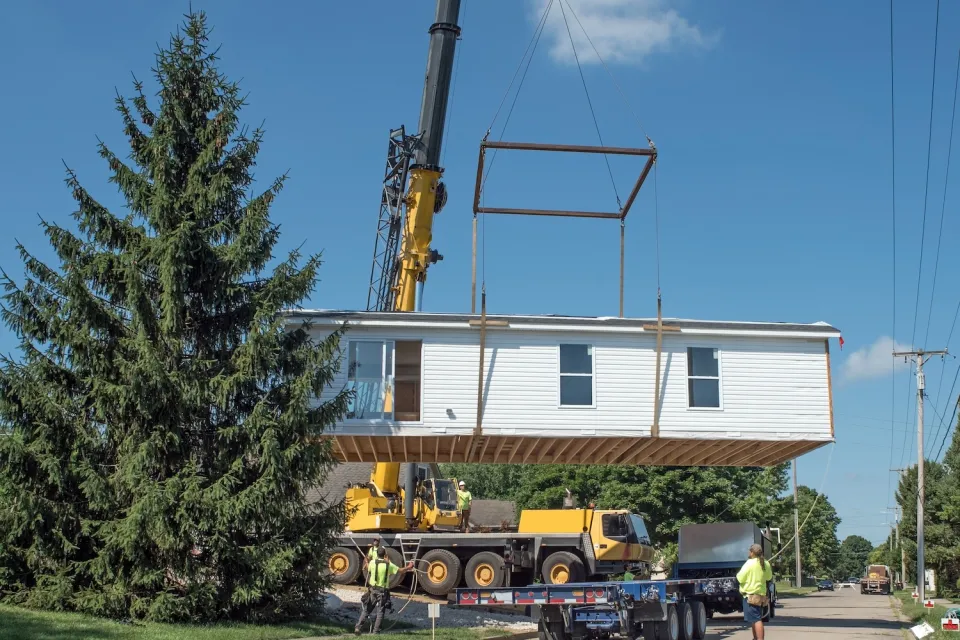 Modular home being lifted with crane.